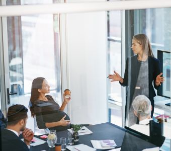 BerufsWege für Frauen und Social Business Women e.V., Weiterbildung für Frauen, Präsentation vor Team mit schwangerer Frau, in hellem und modernen Büro