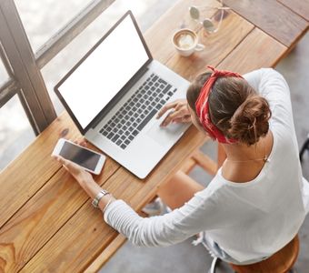 Workshop online Marketing BerufsWege für Frauen-Frau sitzt am Tisch mit Laptop und Smartphone, von oben fotografiert