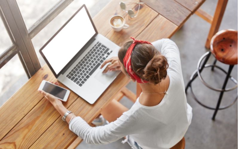 Workshop online Marketing BerufsWege für Frauen-Frau sitzt am Tisch mit Laptop und Smartphone, von oben fotografiert